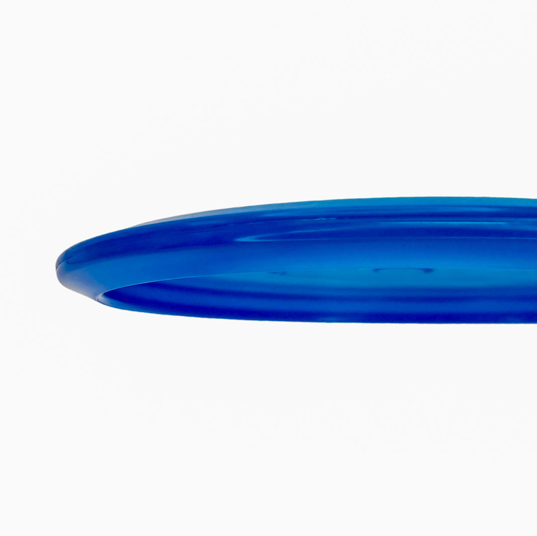 Close-up of the Mystic - Diamond blue disc golf disc against a white background, highlighting its edge and surface—ideal for players seeking a controllable mid-range with straight flight.