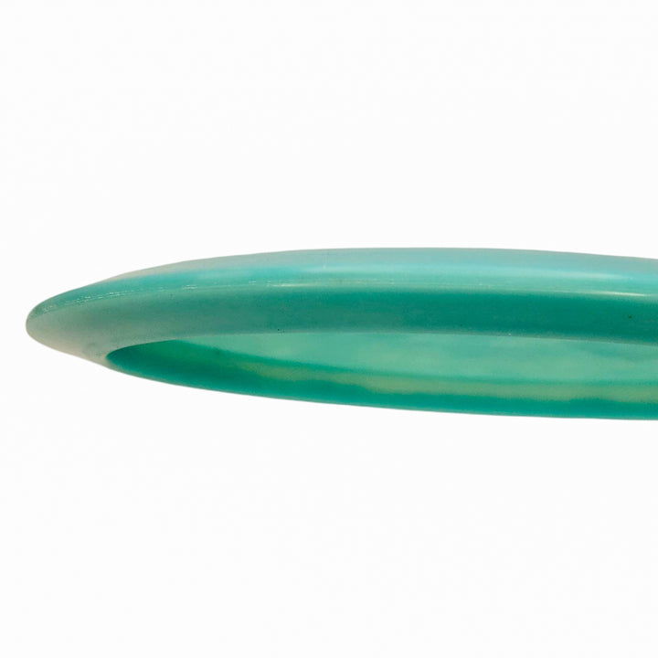 A close-up side view of the Cyborg - NXT Superglow, a turquoise understable disc ideal for controlled throws, shown against a plain white background.