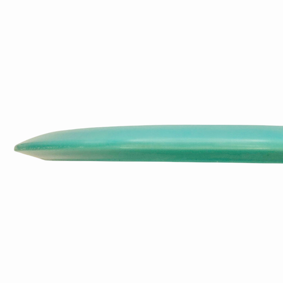 Close-up of the edge of a Cyborg - NXT Superglow fairway driver surfboard in light blue-green against a white background.