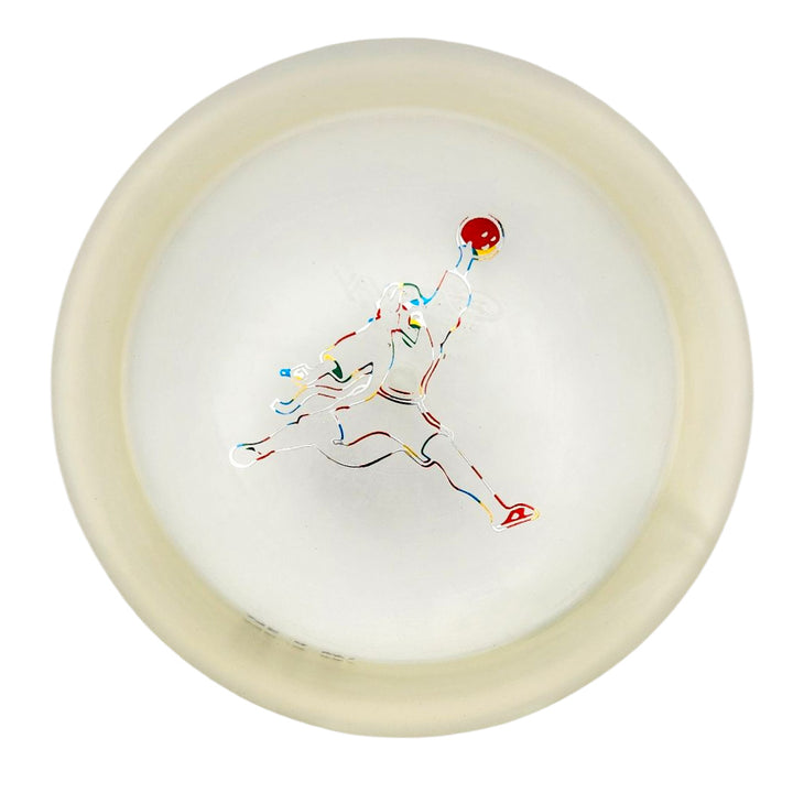 The Spell - Diamond - Air Dude is a translucent white, high-grade TPU disc with an outline of a person midair holding a red ball—ideal for powerful, wind-crushing throws.