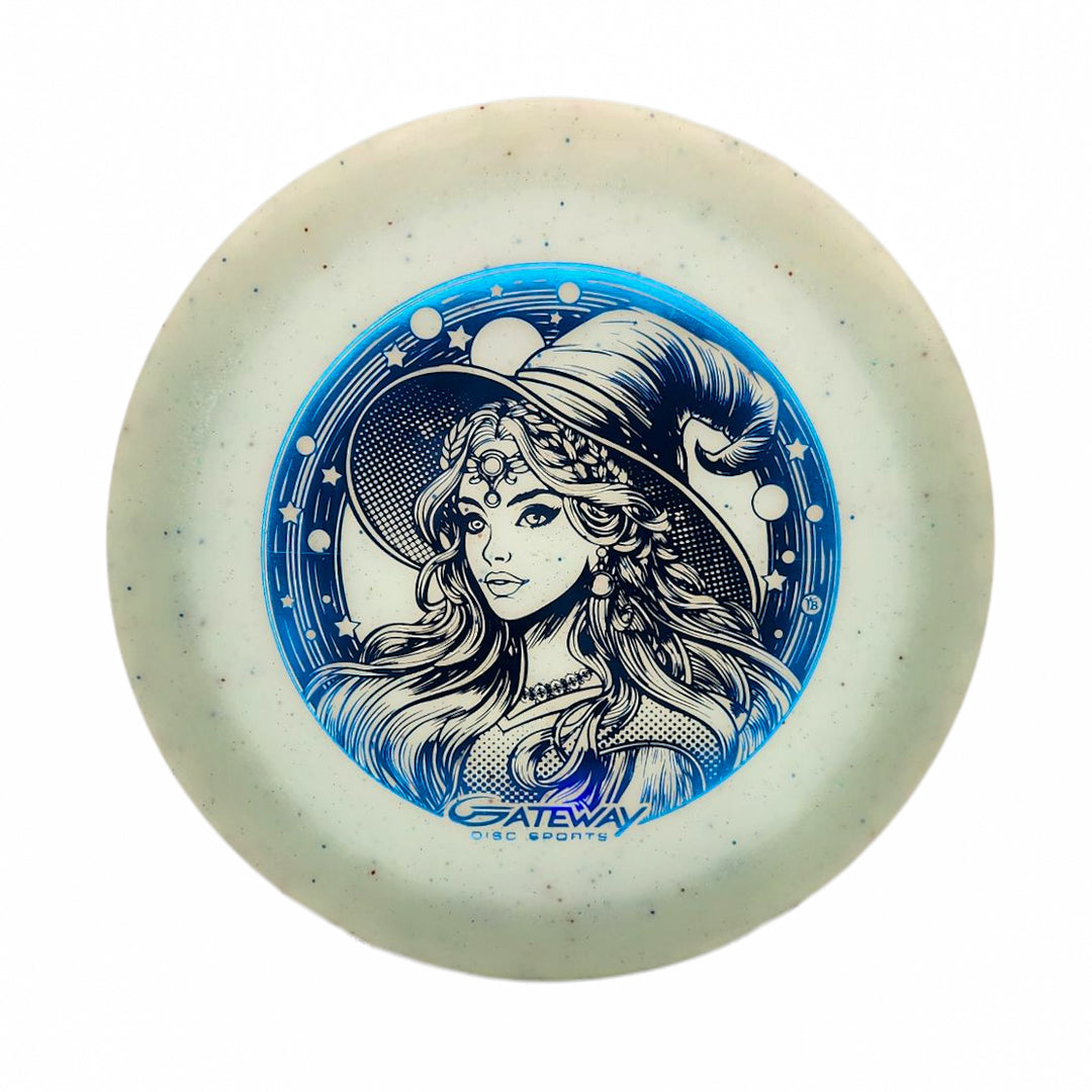 The Spell NXT Superglow - PremierJul is a white glow plastic disc golf disc with a blue design of a woman in a pointed hat and decorative pattern, plus the "Gateway Disc Sports" logo—ideal for overstable driver fans.