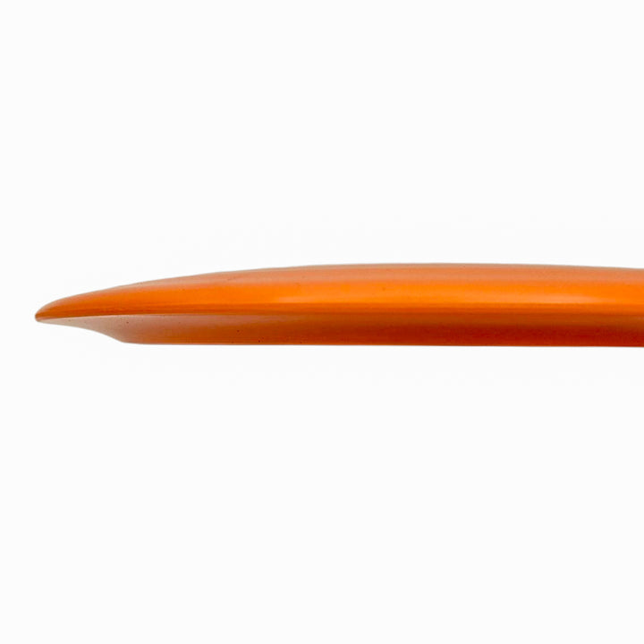 Side view of Spell NXT Lite - PremierJUL surfboard in orange against a white background, highlighting its curved and streamlined shape.