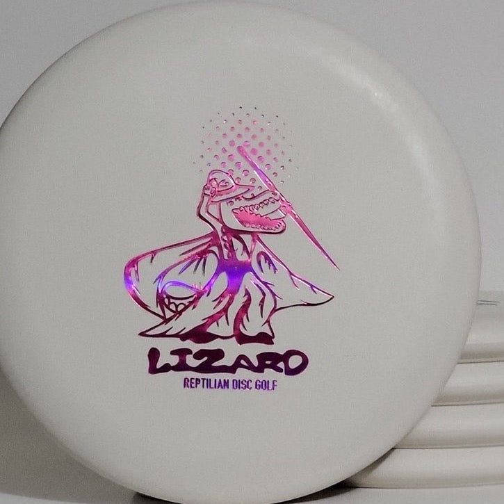 The Reptilian Wizard - FOSSIL disc showcases a caped lizard holding a disc with "LIZARD REPTILIAN DISC GOLF" in purple—ideal for collectors and Fossil Wizards alike.
