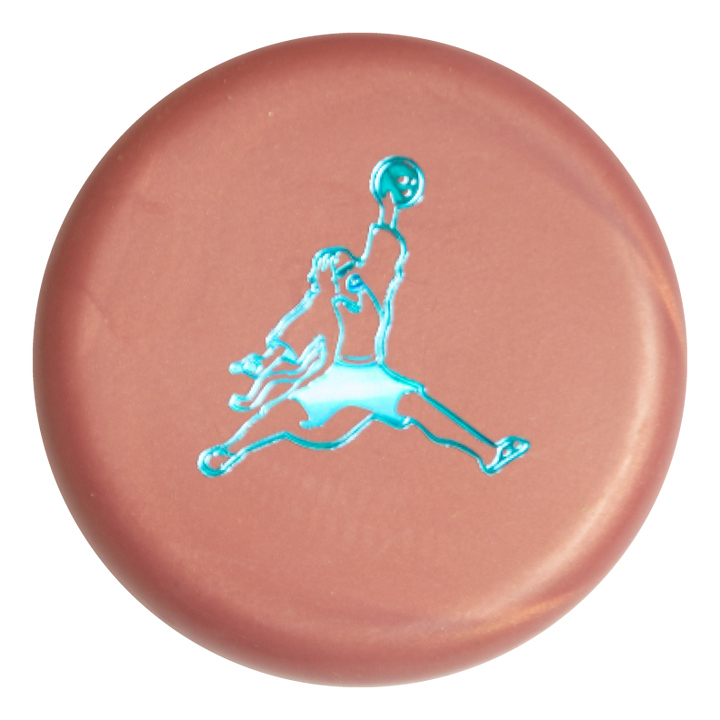 The Air Dude Mini (Large) - SureGrip is a round, metallic pink button featuring a blue basketball player silhouette leaping mid-air with a ball.