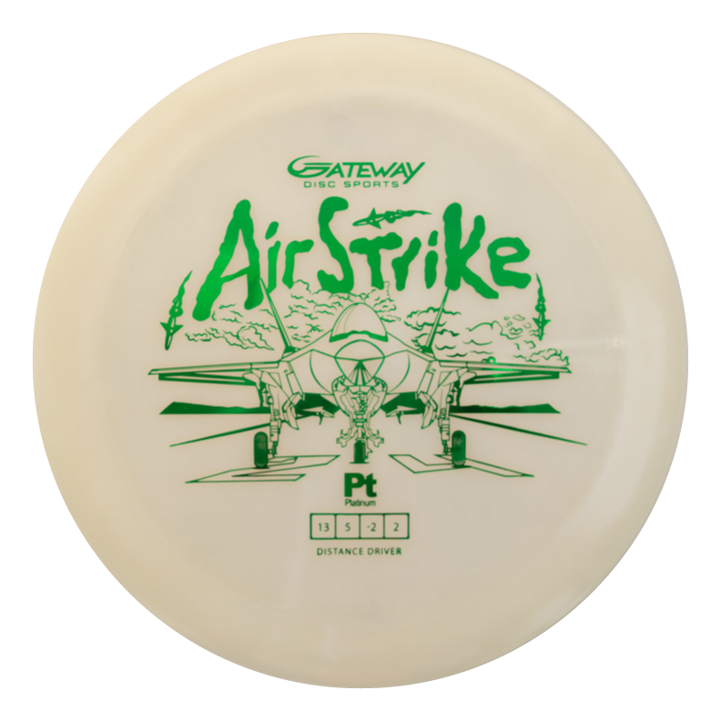 The Airstrike - Platinum is a white long-range driver with green fighter jet artwork, the words "Air Strike," and specs from Gateway Disc Sports€”ideal for players seeking easy control, distance, and precision.