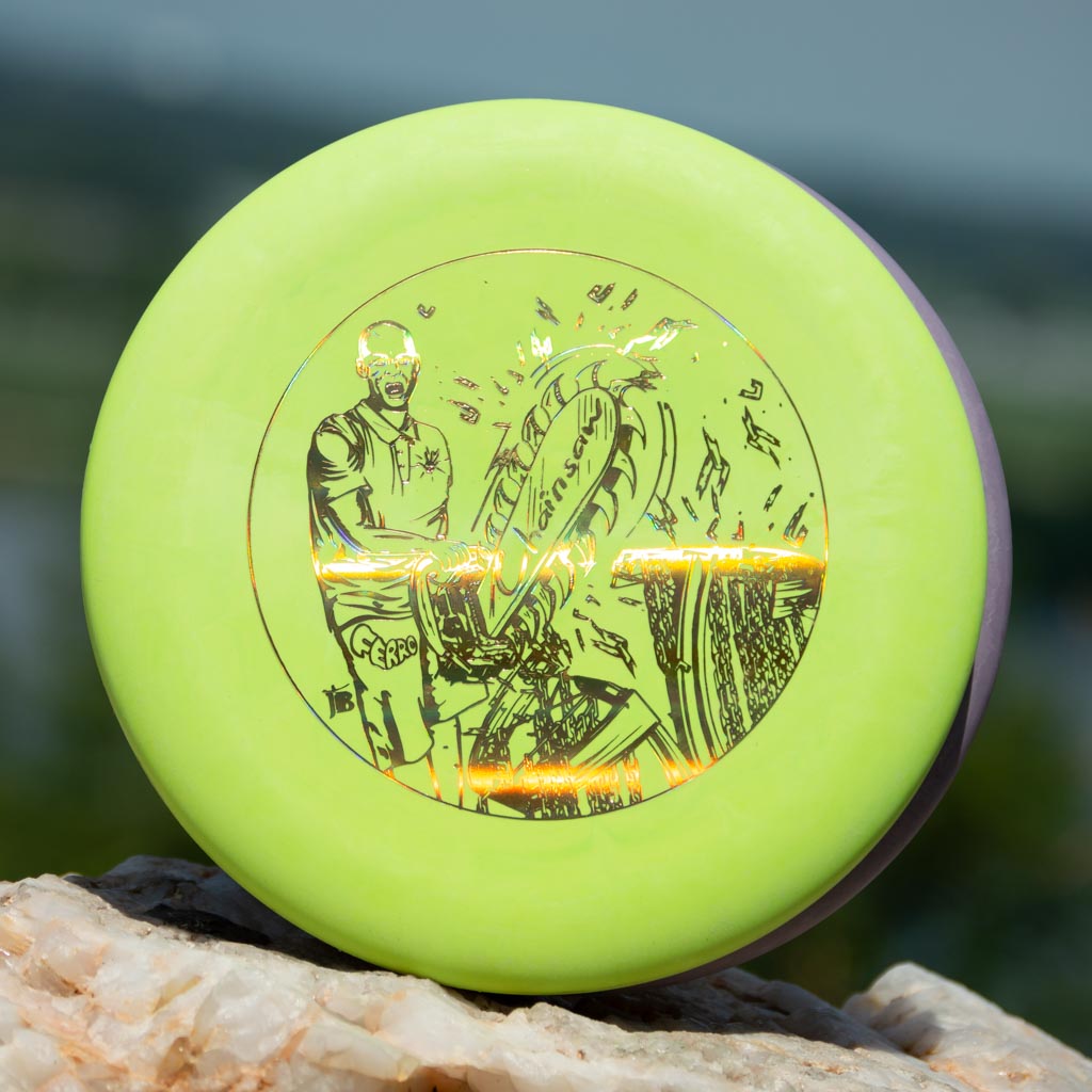 A lime green Black Zombie Chainsaw — SS flying disc featuring a detailed cyclist and bicycle illustration at its center, shown resting on a rock outdoors—a perfect stable putter for your collection.