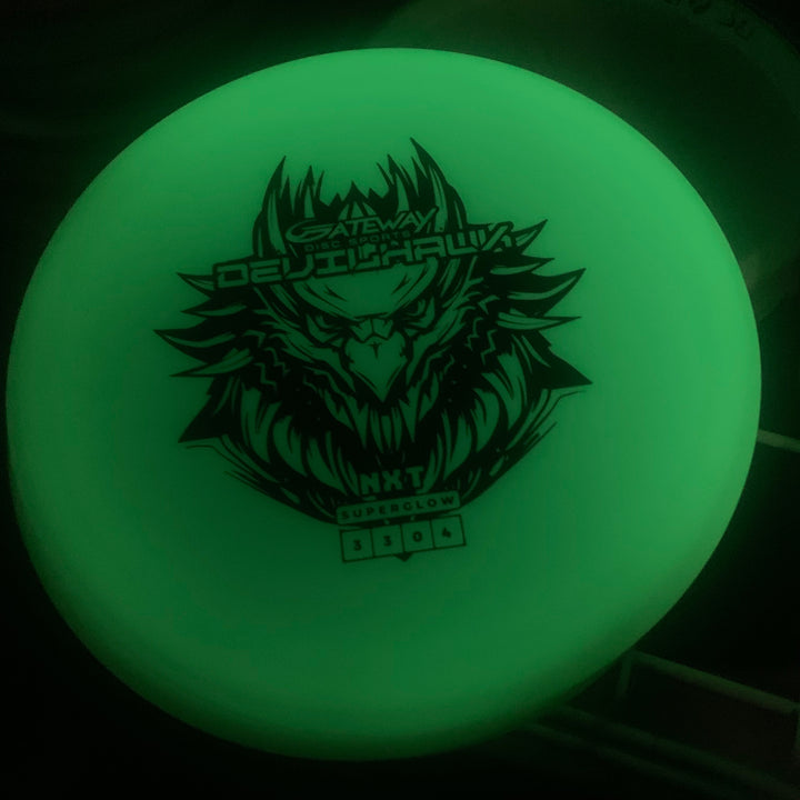 The Devilhawk - NXT Superglow is a glowing, overstable putt and approach disc featuring a stylized eagle graphic, made from durable disc golf plastic for reliable performance.