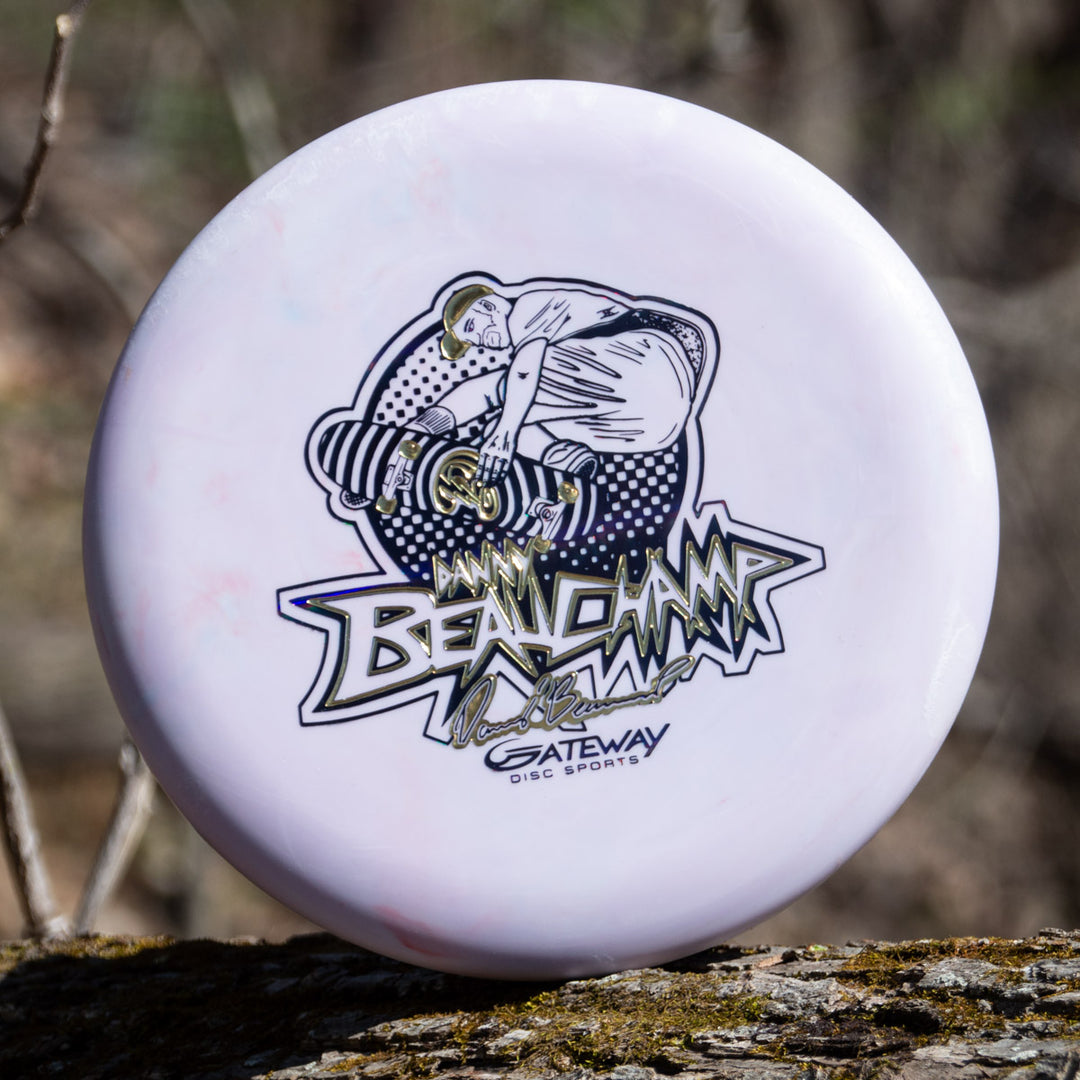 A white disc golf disc with a black and gold player design, featuring "Danny Beauchamp" and "Gateway Disc Sports," celebrates the Danny Beauchamp's Signature Retro Wizard - SS - Superglow from Gateway.
