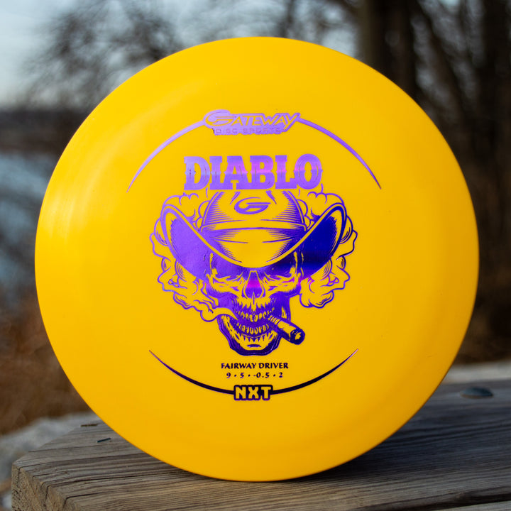 The Diablo - NXT is a yellow overstable fairway driver from Gateway Disc Sports, featuring a purple skull in a cowboy hat with a cigar—ideal for distance flex shots.
