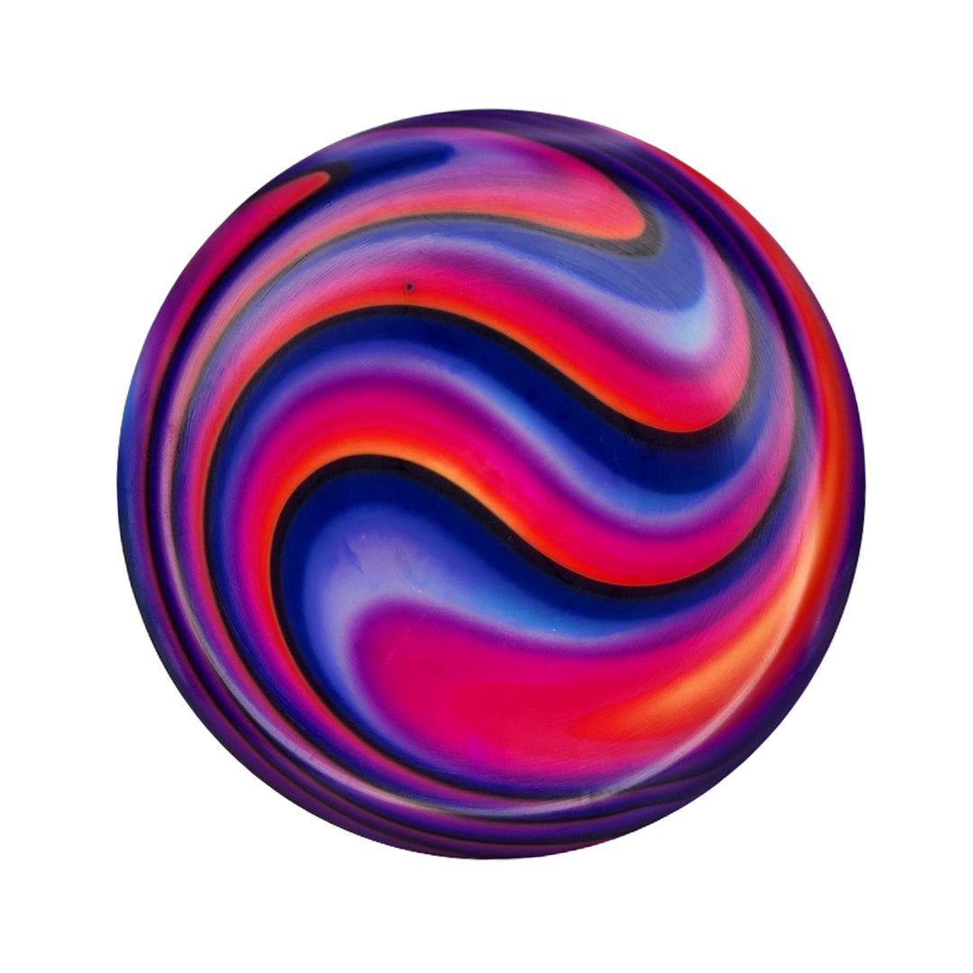 The Element NXT Optic Dyes is a round, smooth hand-dyed disc with swirling pink, red, blue, purple, and orange patterns on a white background.