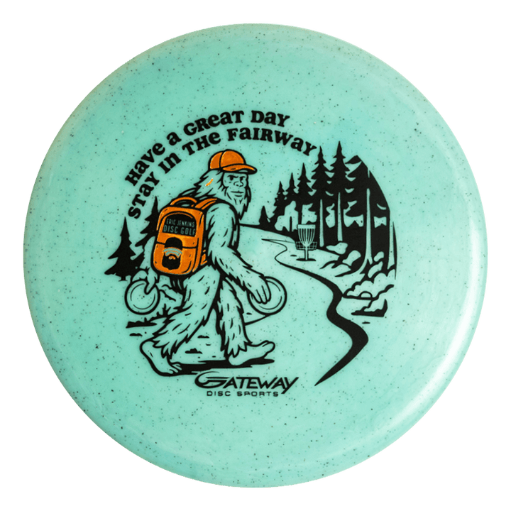 The Eric Jenkins Signature Series Chief - Diamond Hemp is a turquoise off-the-tee putter disc featuring Bigfoot carrying discs, walking down a forest path toward a basket, with —Have a Great Day, Stay in the Fairway—� text.