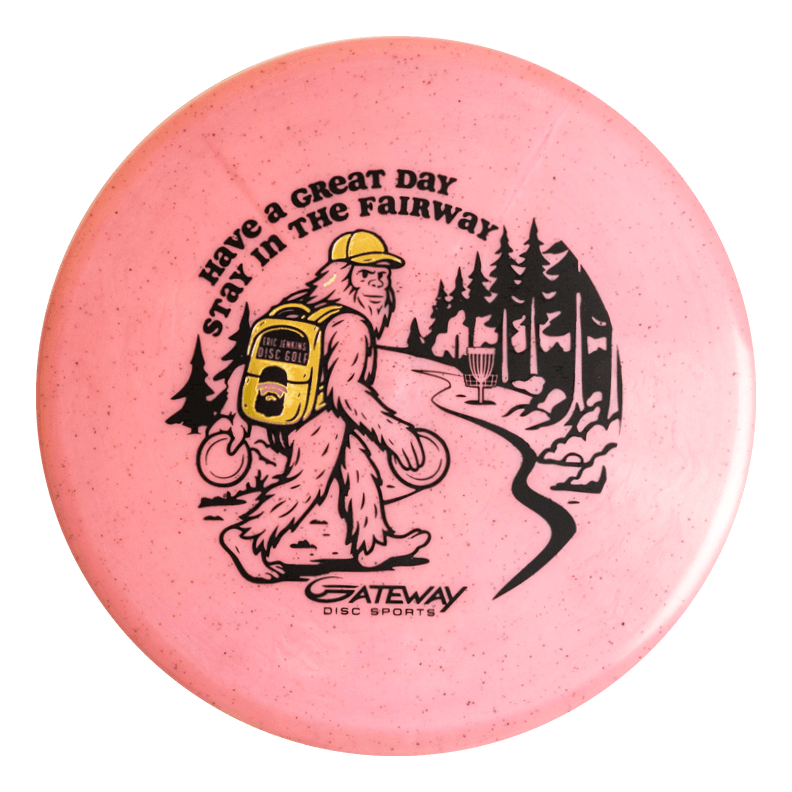 The Eric Jenkins Signature Series Chief - Diamond Hemp is a pink disc golf putter featuring Bigfoot carrying discs and a yellow backpack on a wooded path, with "Have a Great Day Stay in the Fairway" text. Ideal for unique art fans and low profile putters.