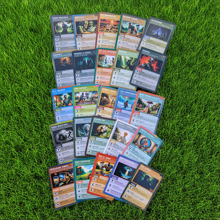 A set of Legends of the Chains: On-Course Disc Golf Game character cards is displayed on green grass, showcasing unique artwork, stats, and disc golf-themed details.