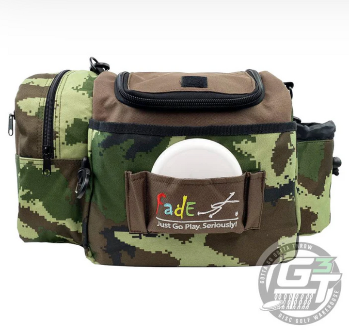 The Fade Gear Crunch Box Disc Golf Bag is a camouflage disc golf bag with multiple pockets, a padded shoulder strap, and an embroidered "Fade; Just Go Play. Seriously!" patch. A white disc is visible in the front pocket.