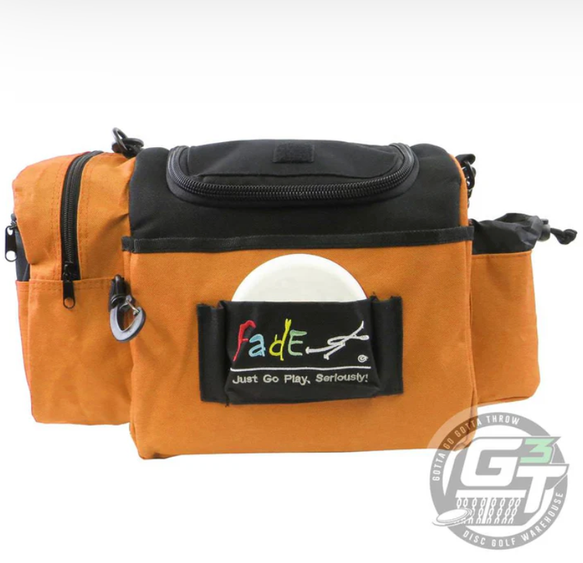 The Fade Gear Crunch Box Disc Golf Bag is an orange and black, durable bag with multiple zippered compartments, a disc-holding front pocket, padded shoulder strap, and "Fade" logo—ideal for everyday disc golf play.