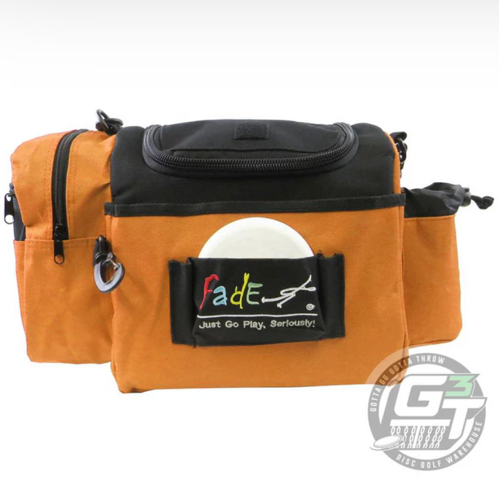 The Fade Gear Crunch Box Disc Golf Bag is an orange and black, durable bag with multiple zippered compartments, a disc-holding front pocket, padded shoulder strap, and "Fade" logo—ideal for everyday disc golf play.