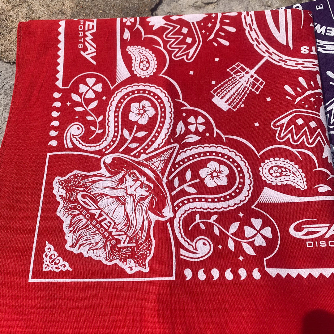 The Gateway Bandana is a red cotton accessory with white graphics, including a wizard with glasses and a hat, paisley and flower patterns, "SLEWAV SPORTS," and Gateway logos for extra flair.