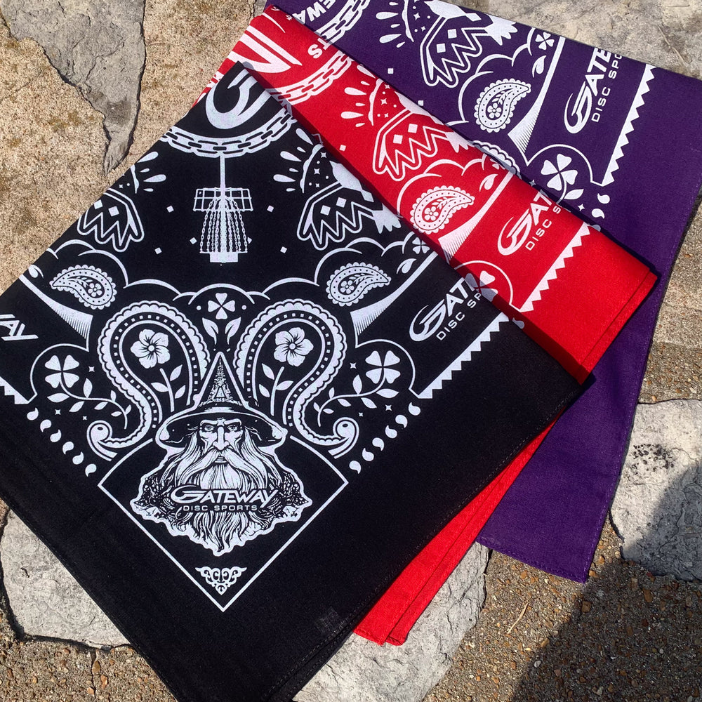 Three Gateway Bandanas in black, red, and purple display intricate patterns, a wizard illustration, and subtle Gateway logos—all shown on a stone background.