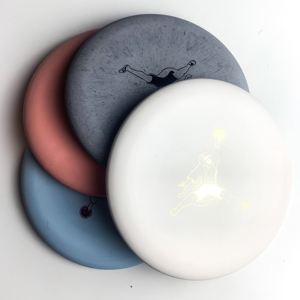Four round discs in gray, pink, blue, and white overlap slightly, each with a person holding a disc—perfect for fans of the Wizard Pure White - Air Dude style.