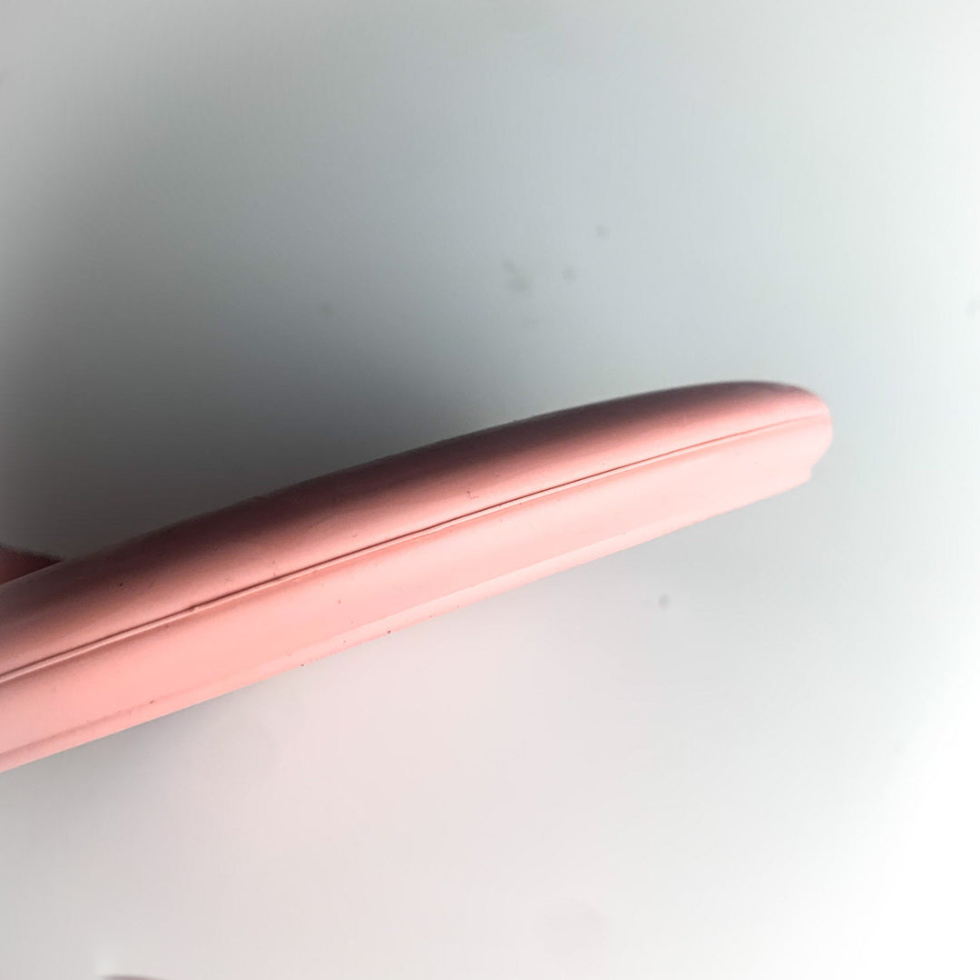 Close-up view of the edge of a pink Wizard Eraser - Air Dude against a plain white background.