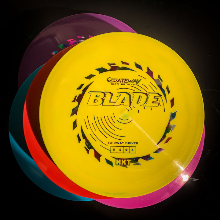 Three vibrant disc golf discs are stacked, with the top yellow disc labeled "Blade - NXT," recognized for its overstable fairway driver design and reliable resistance on forehand shots.