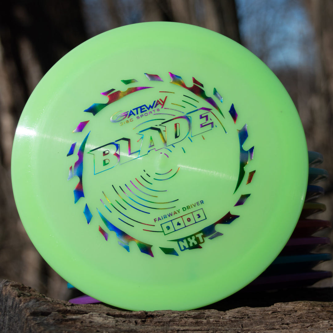 A neon green Blade - NXT overstable fairway driver by Gateway Disc Sports stands on a tree stump outdoors, ready for steady resistance and precise forehand throws.
