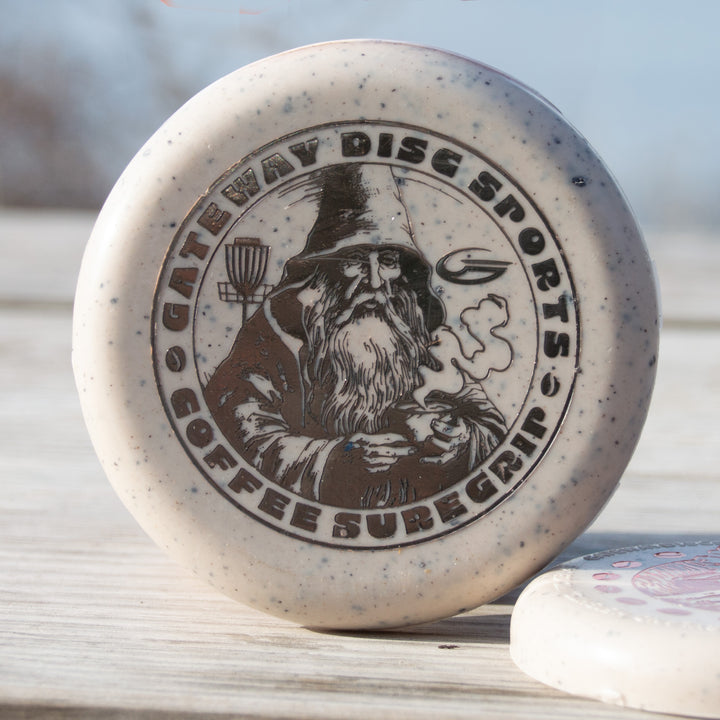 The Coffee Minis is a beige disc golf putter with a wizard holding coffee and €œGateway Disc Sports Coffee Suregrip€� text€”perfect for coffee lovers and Warlock enthusiasts.