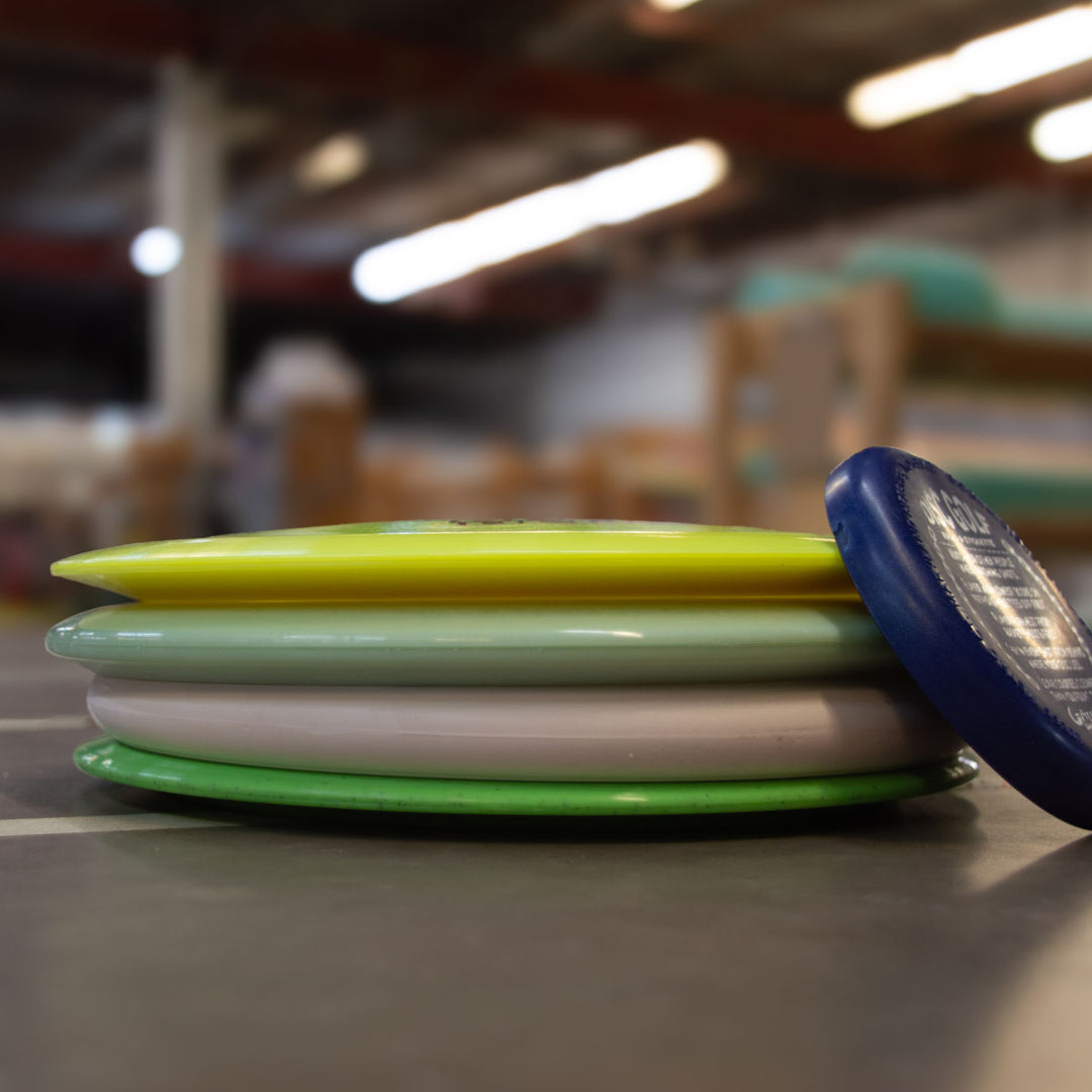 A Factory 2nd 4-Disc Pack featuring assorted colors is stacked on a smooth indoor surface with a blurred background.