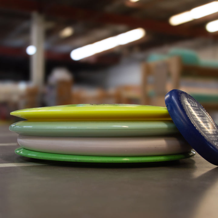 A Factory 2nd 4-Disc Pack featuring assorted colors is stacked on a smooth indoor surface with a blurred background.