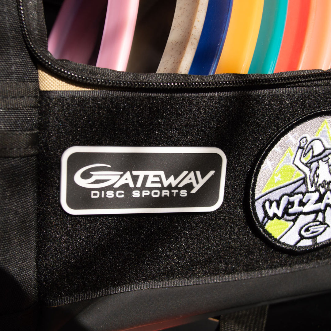 A close-up of a black bag features the Gateway Velcro Logo Patch and several disc golf discs visible inside.