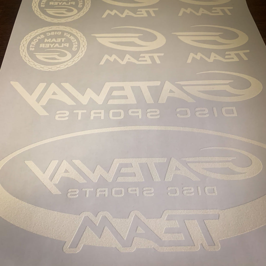 The Iron-On Team G Logo Sheet is a white vinyl decal sheet featuring "Gateway Disc Sports Team" logos, displayed in reverse on backing paper for easy transfer by team players.