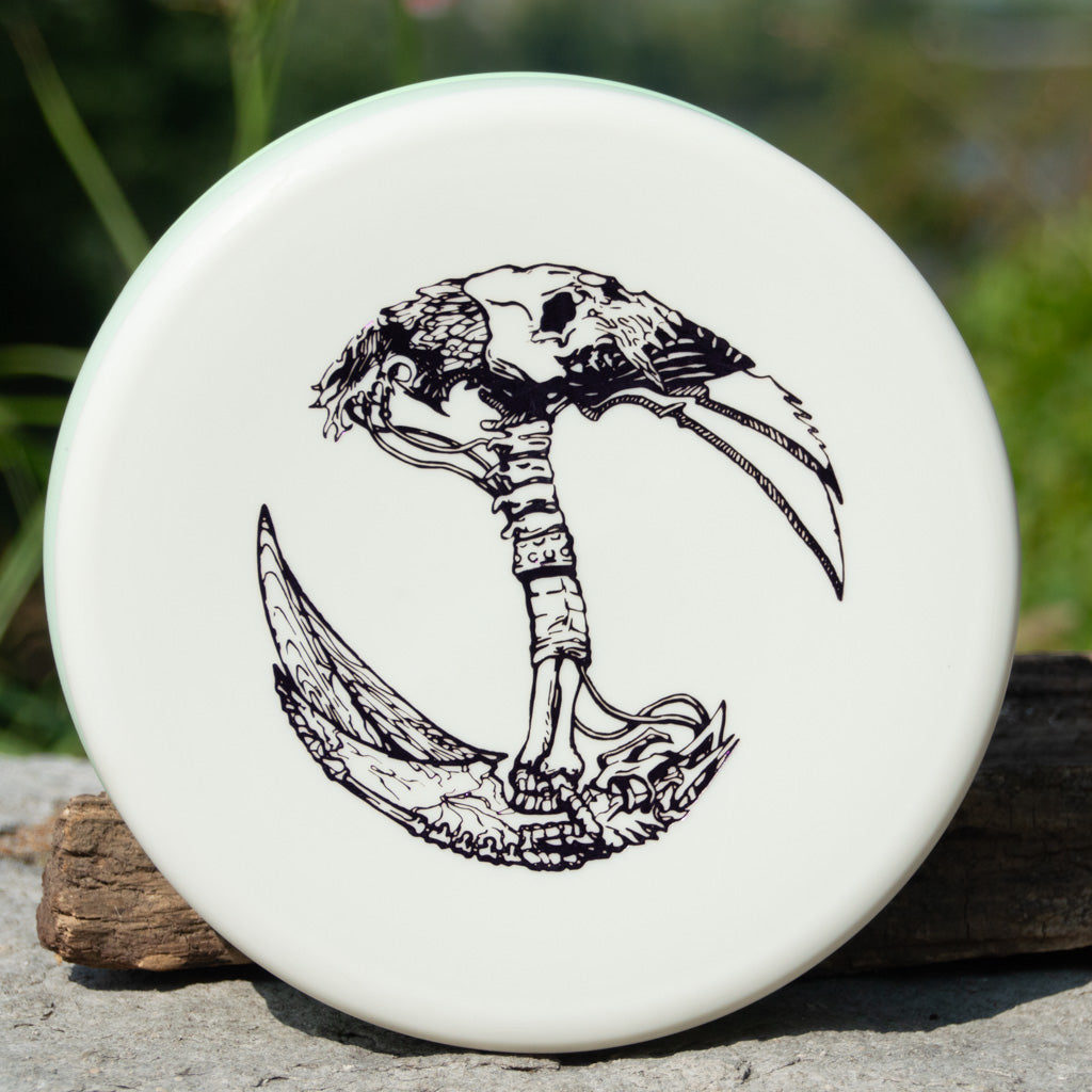 The Brett Stetson Houdini - Superglow, featuring Kevin Hart's black bird skull and talons art in a circular, symmetrical design, is the perfect white putt and approach disc for your next disc golf round.