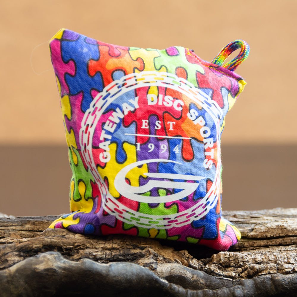 The Gateway Disc Sports x Jaybirdz Dry Bag is a handcrafted, small grip-enhancing chalk bag with a colorful puzzle piece pattern and —Gateway Disc Sports EST 1994—� printed on the front—ideal for disc golf use.