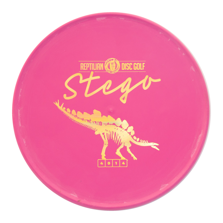 A pink Reptilian DG Stego — Fossil disc with yellow "Stego" text and a dinosaur graphic, famously called the #WorstDiscEverMade for its unique Flight Numbers and unforgettable throwing experience.