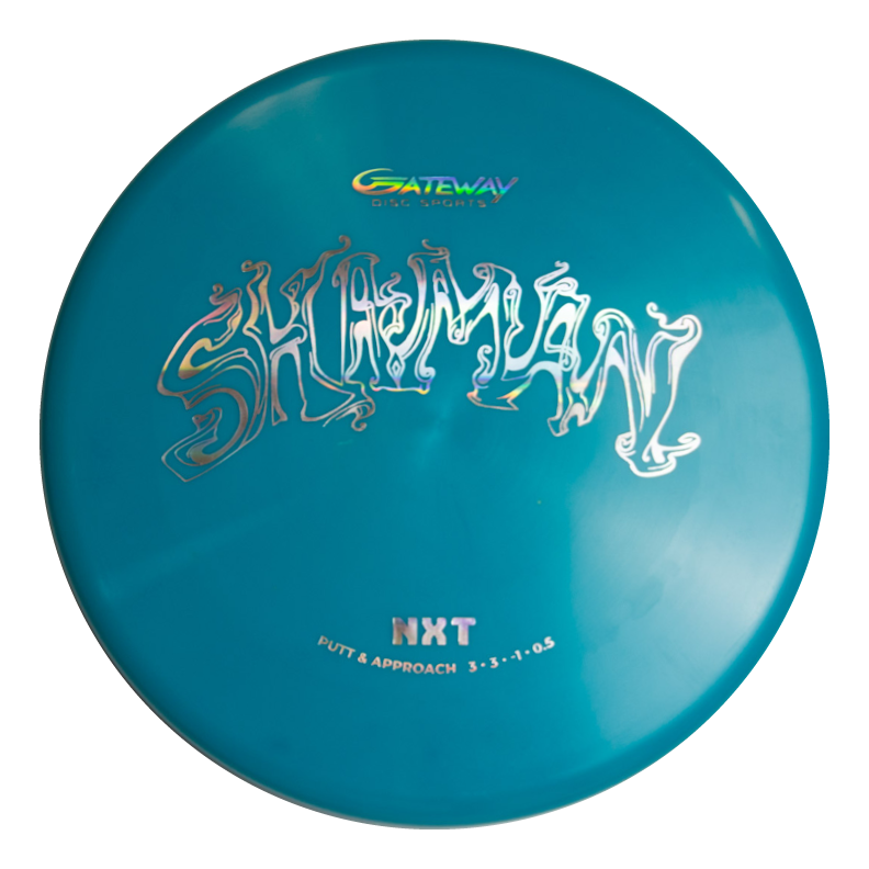 The Shaman - NXT is a teal Gateway disc golf putter with a flat 25° nose, no bead, "Shaman" in stylized white text, and "NXT Putt & Approach 3-3--1-0.5" printed below.