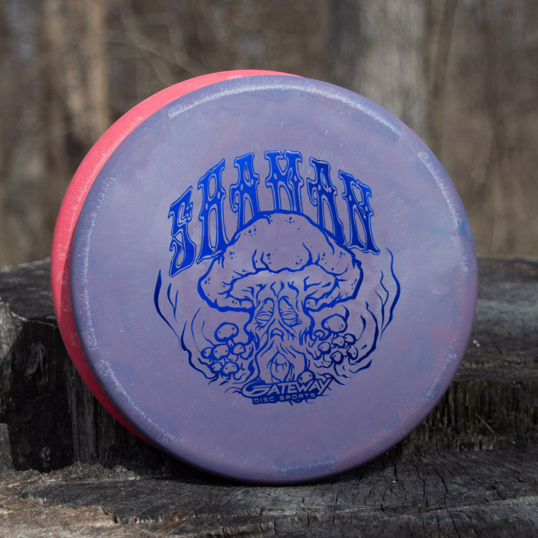 A purple and pink Gateway Shaman - SSS - Mushroom disc with a Special Edition Stamp and flat nose stands upright on a tree stump outdoors.