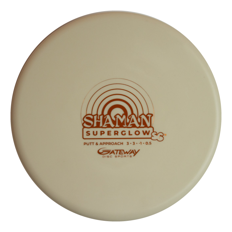 A cream-colored Shaman - SS - Suregrip Superglow putt and approach disc by Gateway Disc Sports, made from glow plastic with a brown rainbow graphic for enhanced visibility.