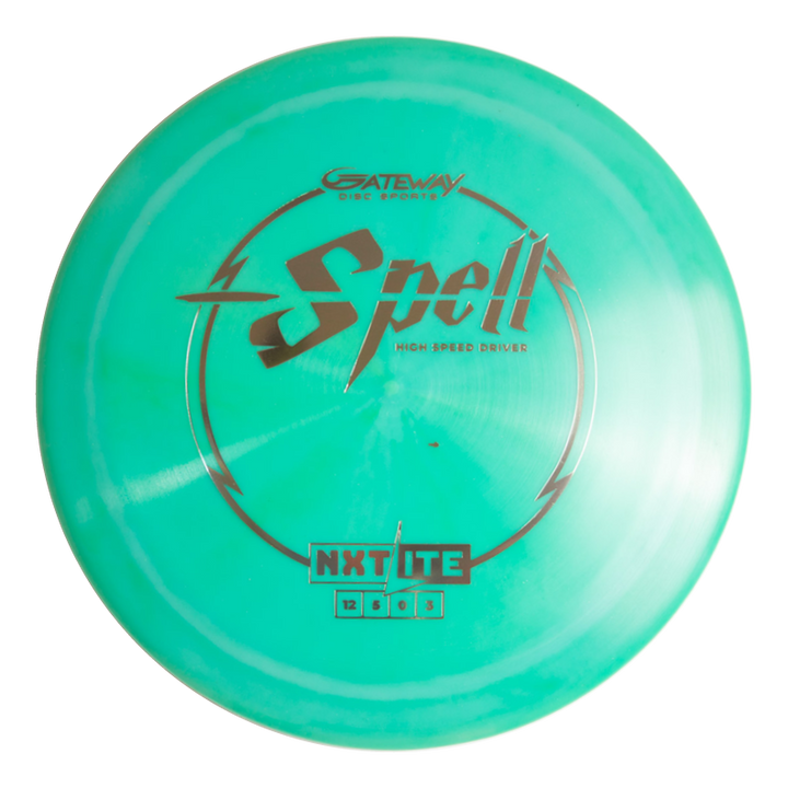 The Spell - NXT Lite is a teal overstable disc golf driver with bold black and silver text, engineered for wind-crushing power throws and consistent full-throttle performance.