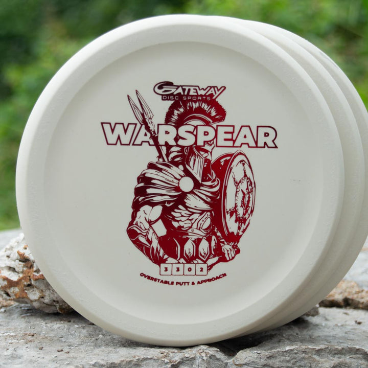A white, low profile Warspear - Suregrip putt and approach disc with an illustration of a warrior holding a spear and shield, and the model name above.