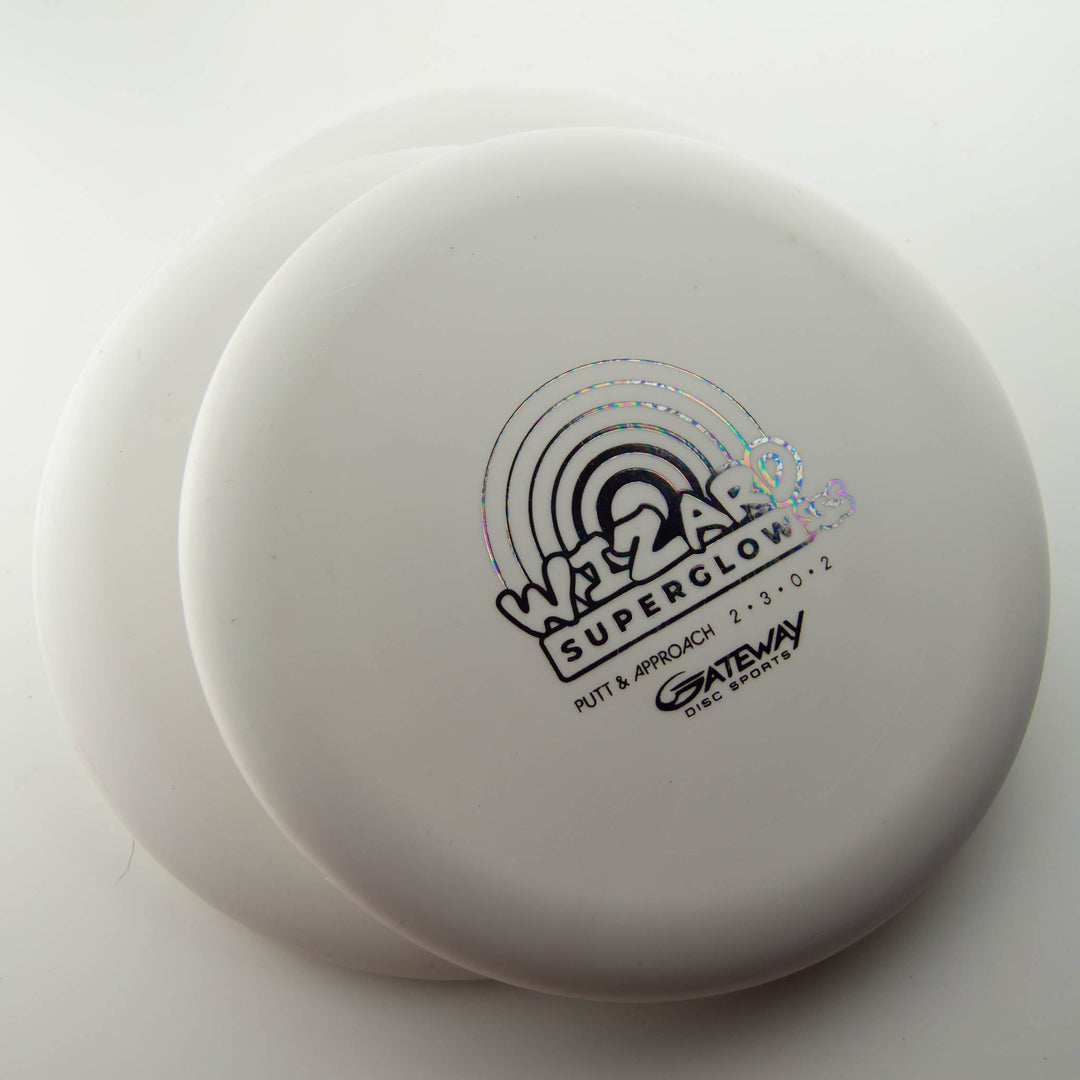 Three white Gateway Wizard - SSS - Superglow putters, known for stability in putts and mid-range drives, are stacked with the top disc displaying a holographic logo and text.