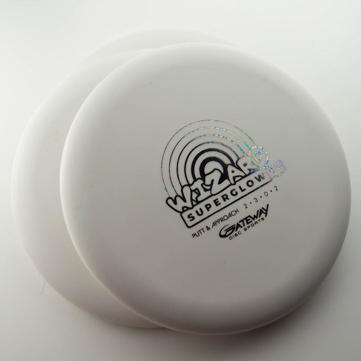 Three white Gateway Wizard - SSS - Superglow putters, known for stability in putts and mid-range drives, are stacked with the top disc displaying a holographic logo and text.