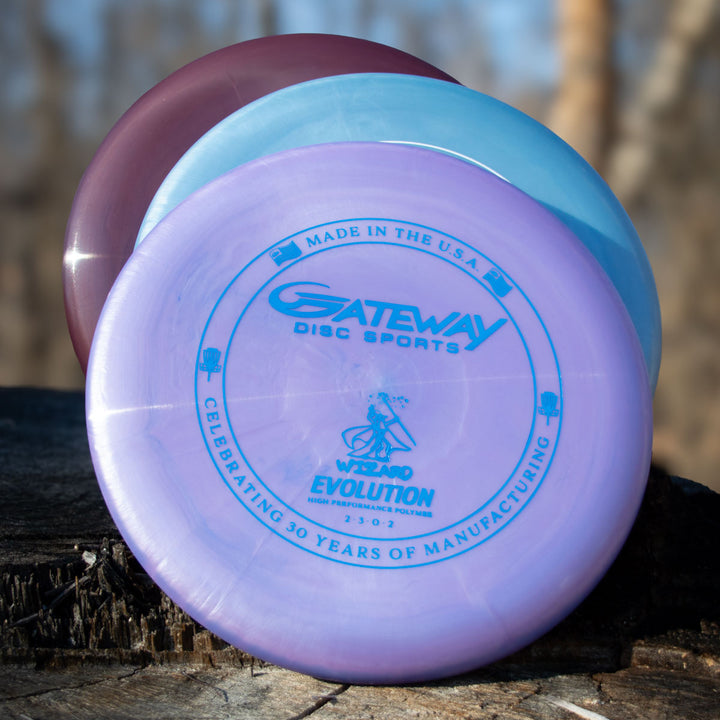 Three Gateway Wizard - Evolution - Galaxy discs are stacked on a tree stump, with the top disc displaying a blue 30th Anniversary logo and text, celebrating 30 years of manufacturing in a special pearl shimmer finish.
