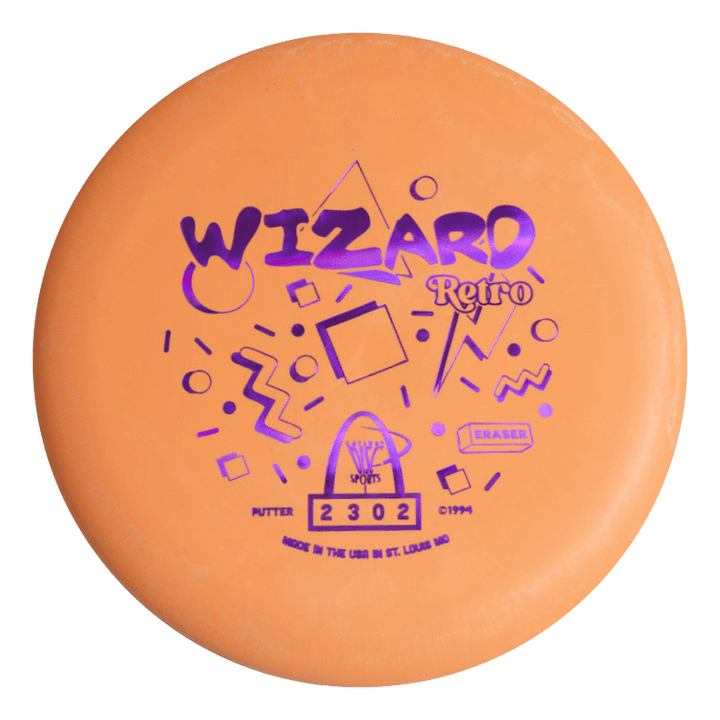 The Retro Wizard - Eraser is an orange disc golf putter from the Retro series, featuring purple geometric patterns and text on the front€”ideal for fans of distinctive putters.