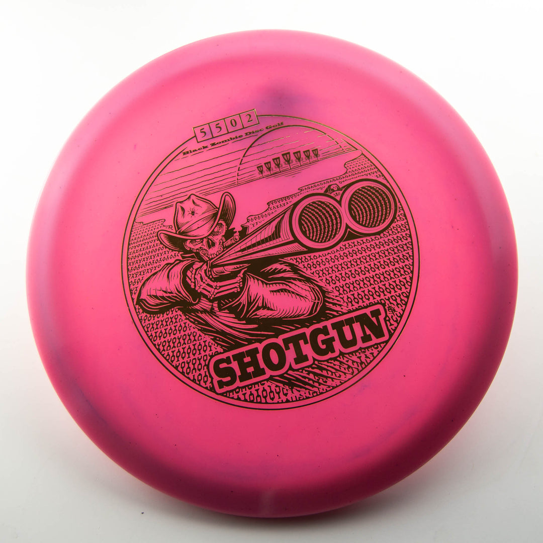The Black Zombie Shotgun — Platinum disc golf disc is pink and features an illustration of a cowboy aiming a shotgun, with "SHOTGUN" printed below the image.