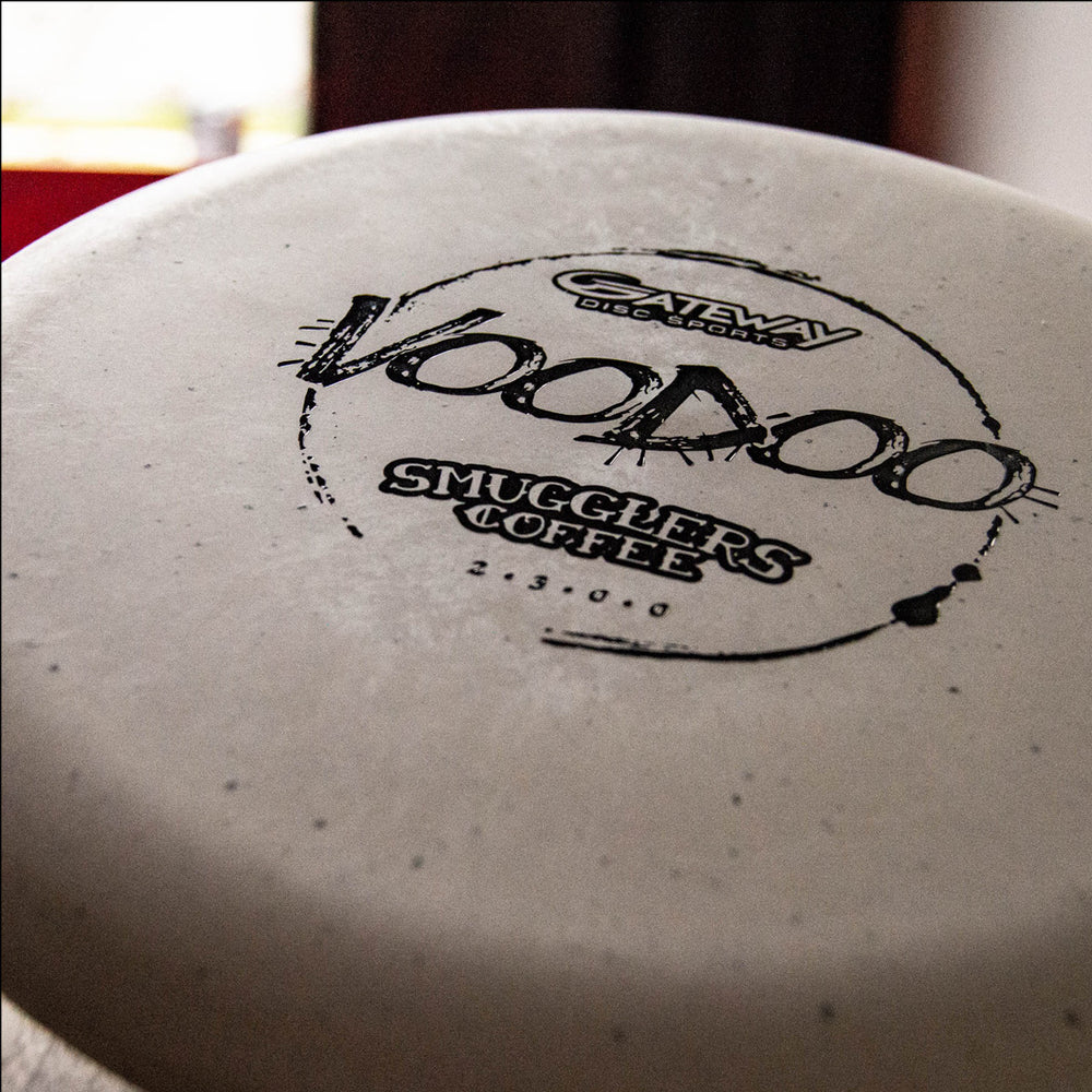 Close-up of the Voodoo - Smugglers Coffee Special Blend disc, featuring white plastic with Smugglers Coffee branding—perfect for disc golfers and coffee lovers celebrating a fresh espresso blend or coffee purchase.