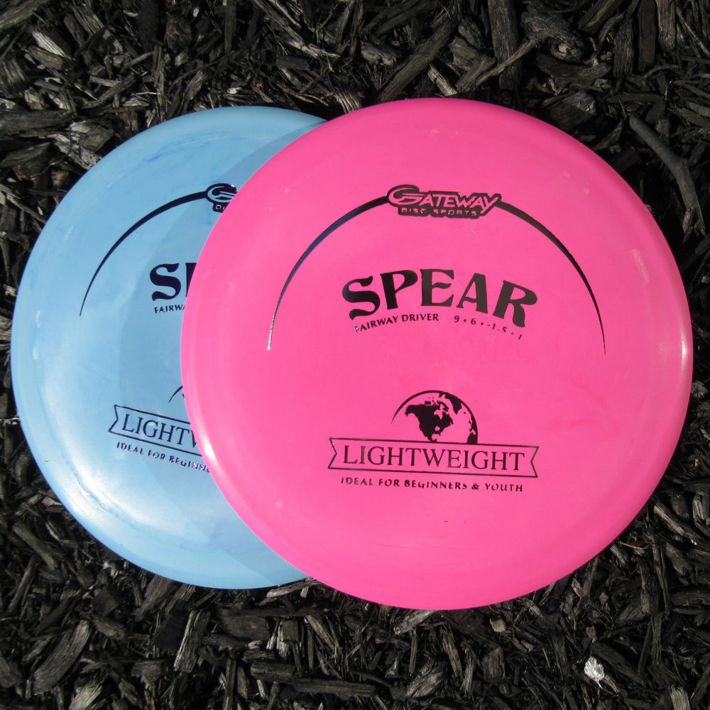 Two pink and blue Spear - SureGrip Lightweight discs rest on dark mulch, ready for accurate placement as reliable control drivers.