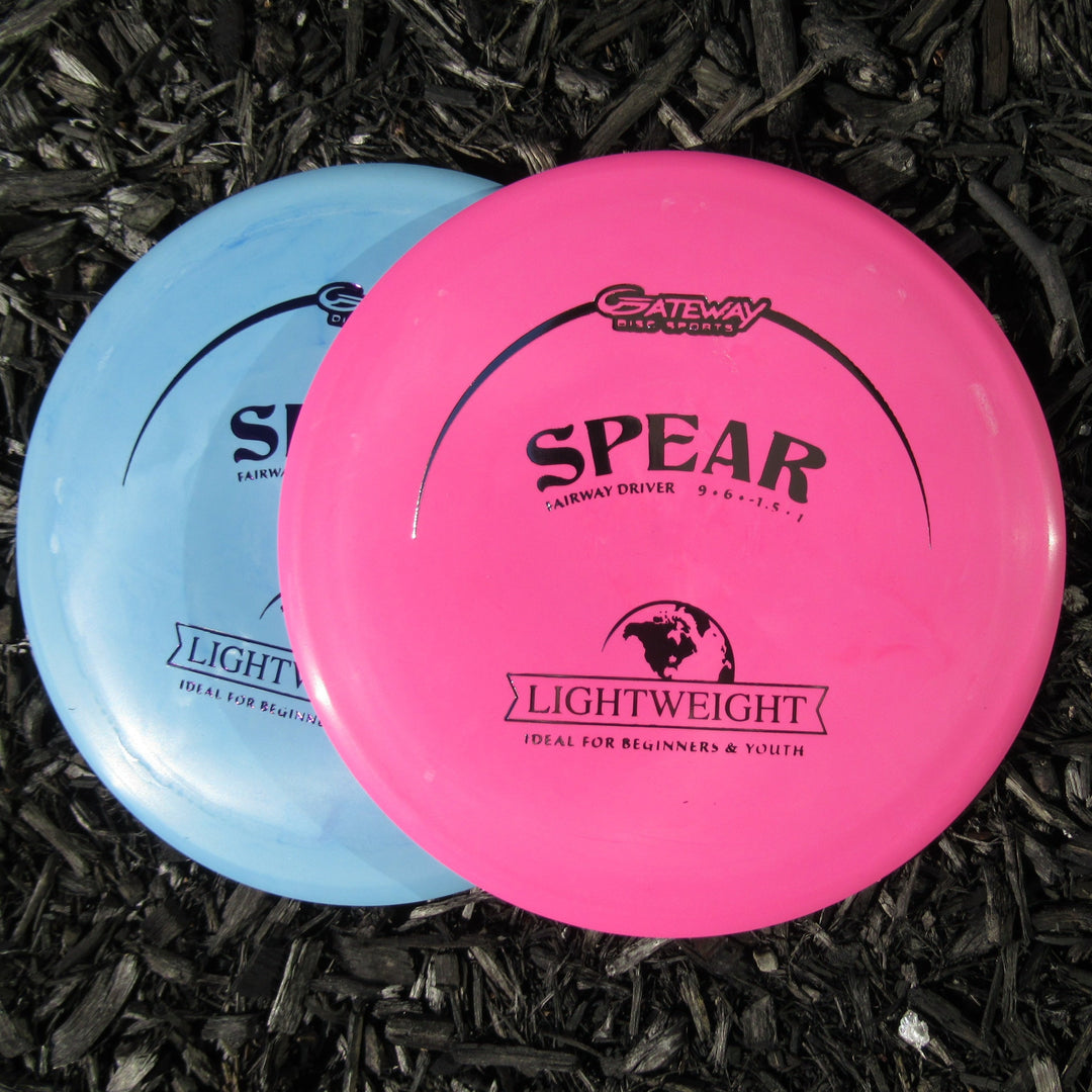 Two pink and blue Spear - SureGrip Lightweight discs rest on dark mulch, ready for accurate placement as reliable control drivers.