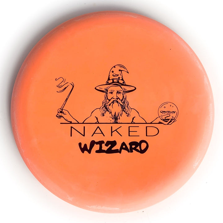 An orange, over-stable Wizard - NAKED - Eraser disc golf disc features a bearded wizard with wand and crystal ball above the text "NAKED WIZARD"€”a magical addition to your collection.