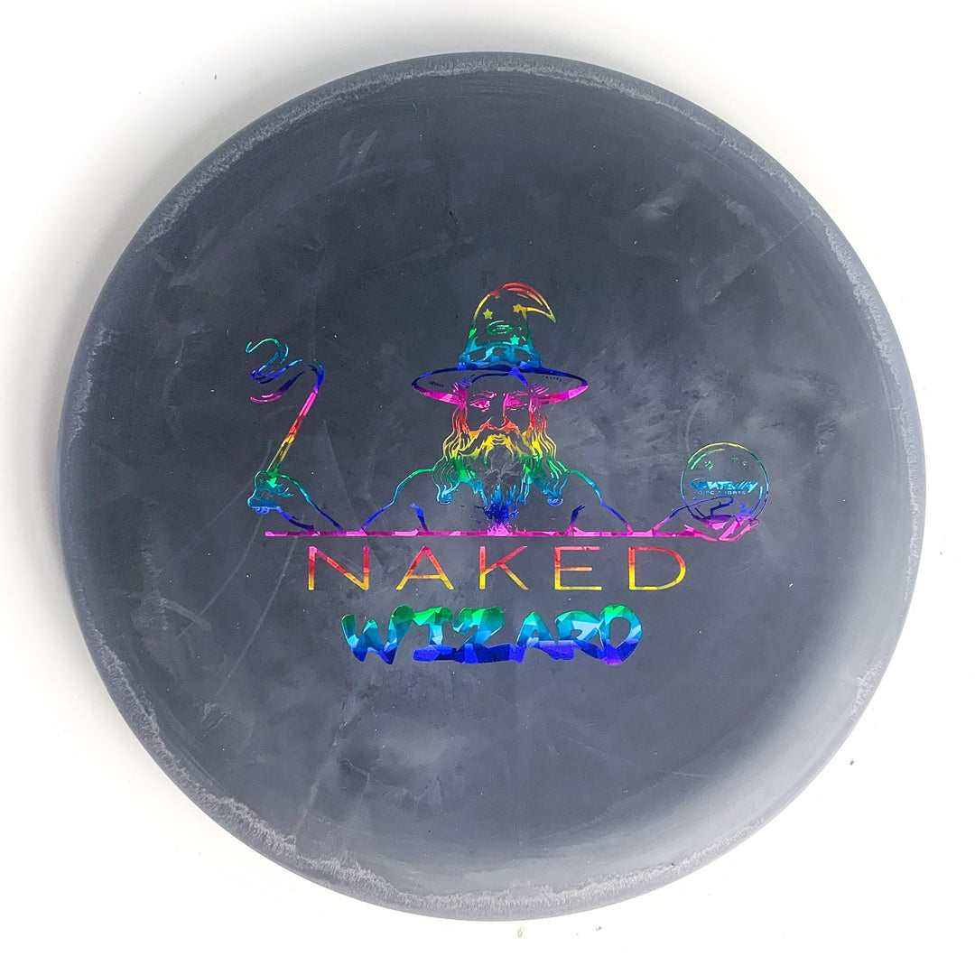The Wizard - NAKED - SS is a round black disc golf disc with a holographic wizard holding a staff and sphere, labeled "NAKED WIZARD" in colorful letters—ideal for fans of Naked Wizards and players needing an over-stable disc.