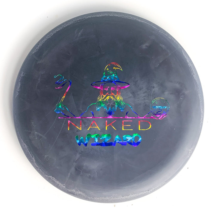 The Wizard - NAKED - SS is a round black disc golf disc with a holographic wizard holding a staff and sphere, labeled "NAKED WIZARD" in colorful letters—ideal for fans of Naked Wizards and players needing an over-stable disc.
